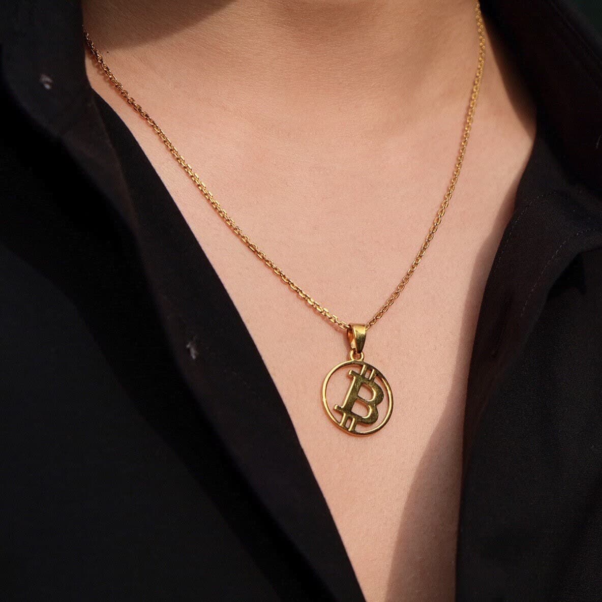 BTC Pendant in gold plating worn over an open black shirt